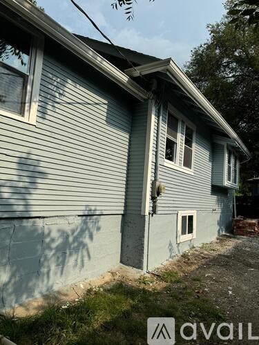A house with a blue siding and a window missing its frame.