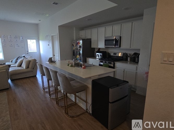 A kitchen with a white island and a refrigerator.