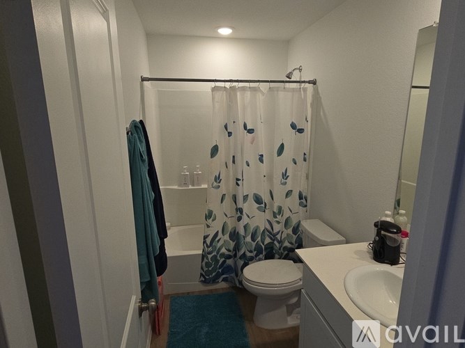A small bathroom with a toilet, sink, and shower curtain.