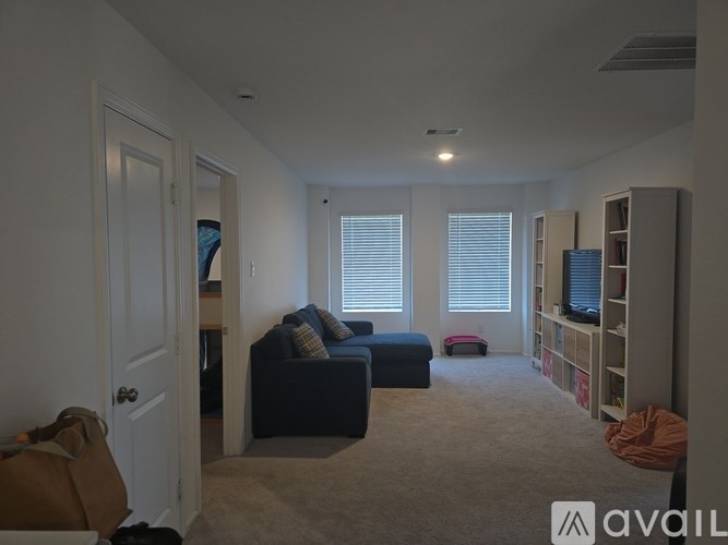 A living room with a couch, a chair, and a television.