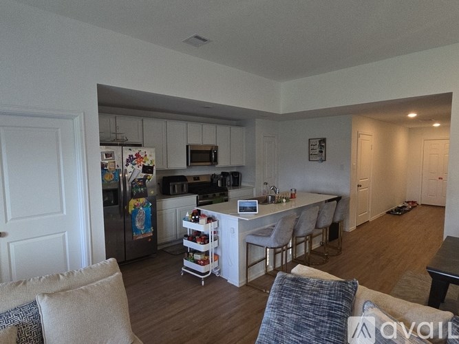 A kitchen with a refrigerator, microwave, and oven.