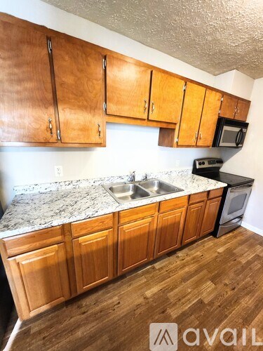 A kitchen with wooden cabinets and a granite countertop.