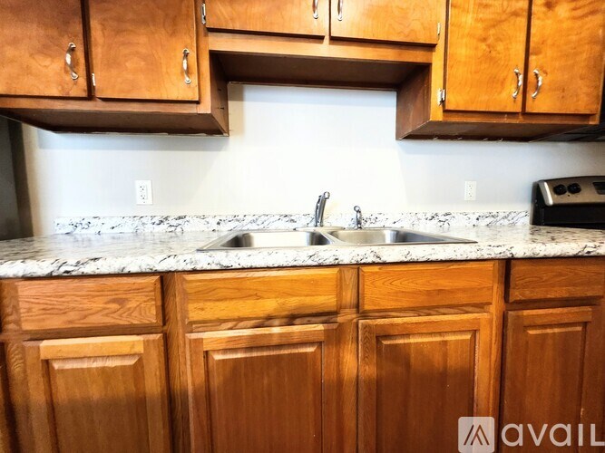 A kitchen with wooden cabinets and a marble countertop.