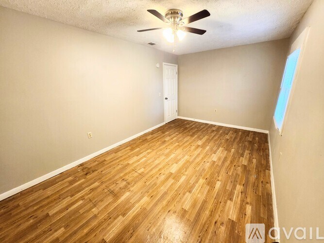A room with wooden flooring and a ceiling fan.