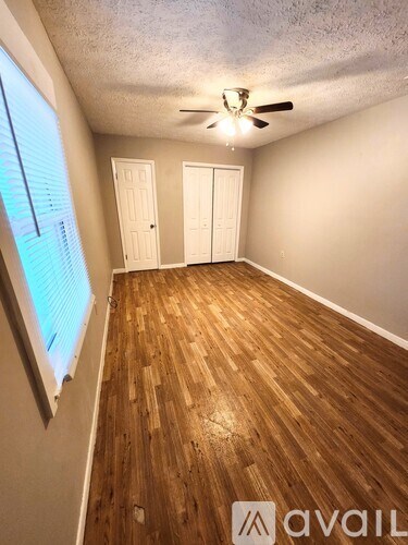 A room with wooden flooring and a ceiling fan.