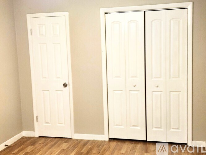 Three white doors in a room.