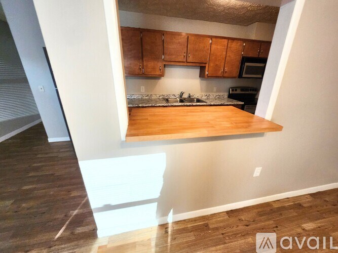 A kitchen with wooden cabinets and a countertop is available for rent.
