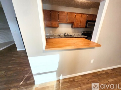 A kitchen with wooden cabinets and a countertop is available for rent.