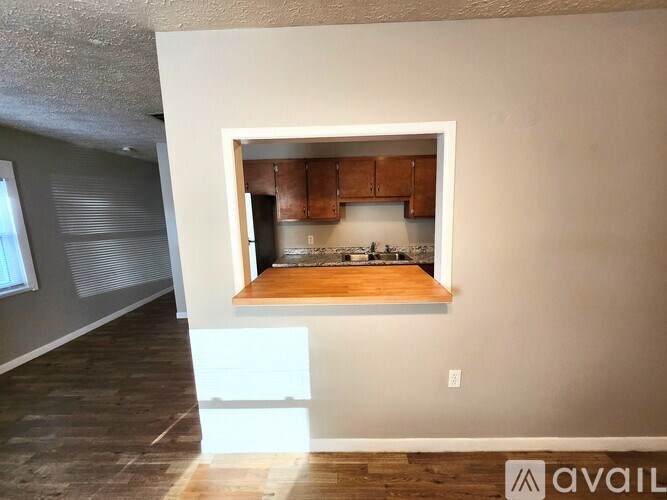 A kitchen area with wooden cabinets and a countertop is available for rent.