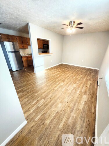 A room with wooden flooring and a ceiling fan.