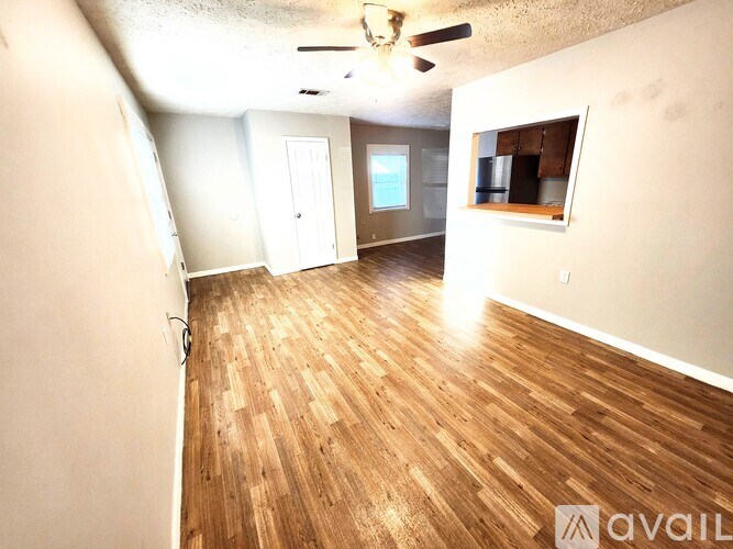 A room with wooden flooring and a ceiling fan.