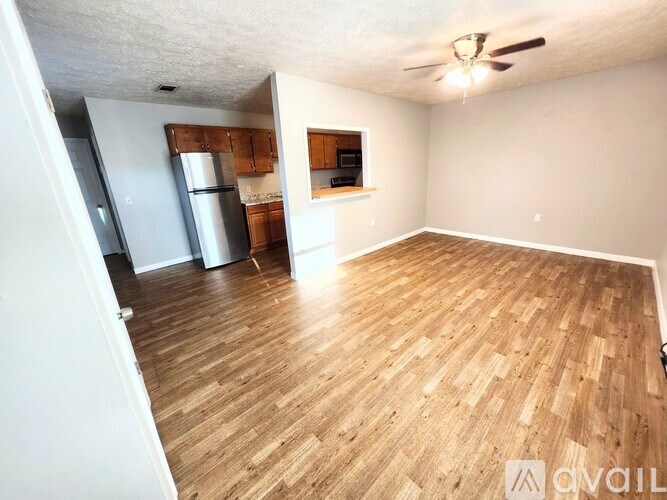 A room with wooden flooring and a ceiling fan.