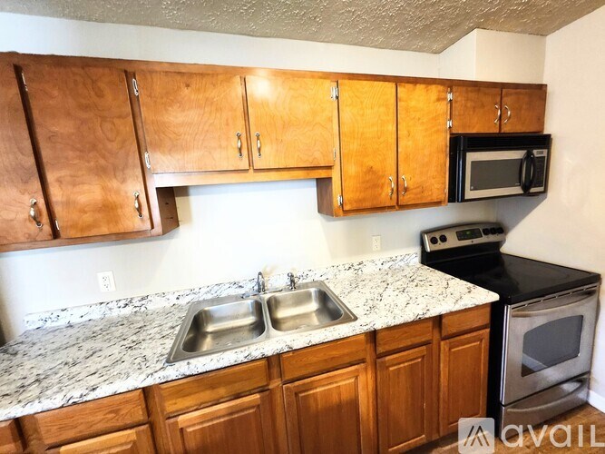 A kitchen with wooden cabinets and granite countertops.