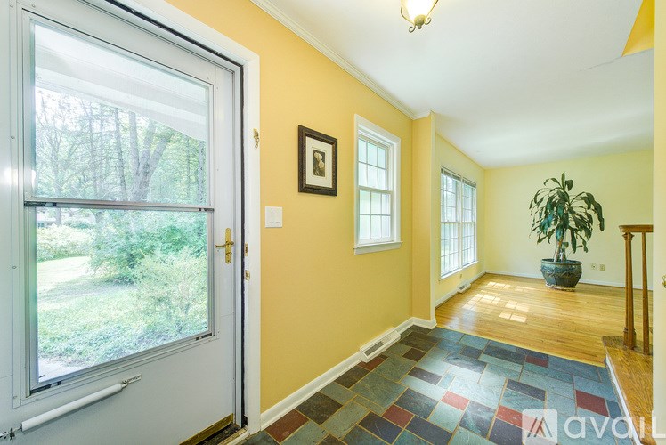 A room with a yellow wall and a tiled floor leading to a door.