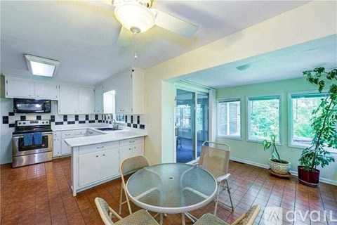 A kitchen with a table and chairs in it.