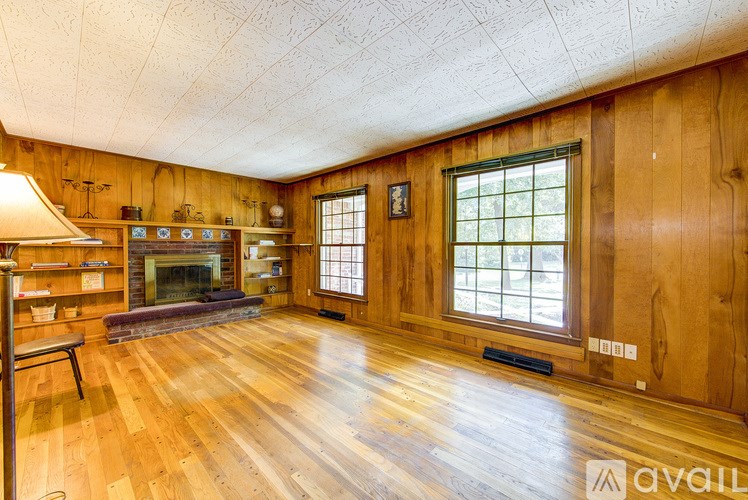 A living room with wood floors and a fireplace.