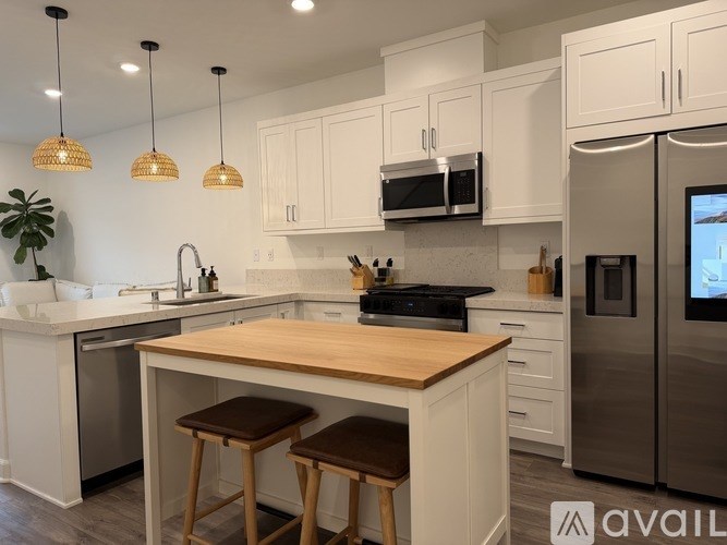 A kitchen with white cabinets and a wooden island.