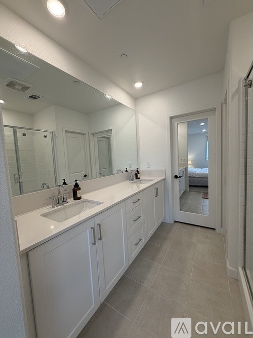 A bathroom with a sink, mirror, and cabinets.