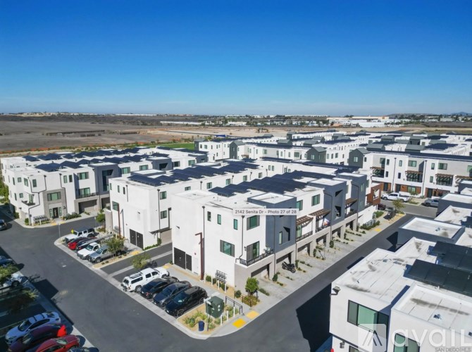 Apartment complex with a parking lot in front.