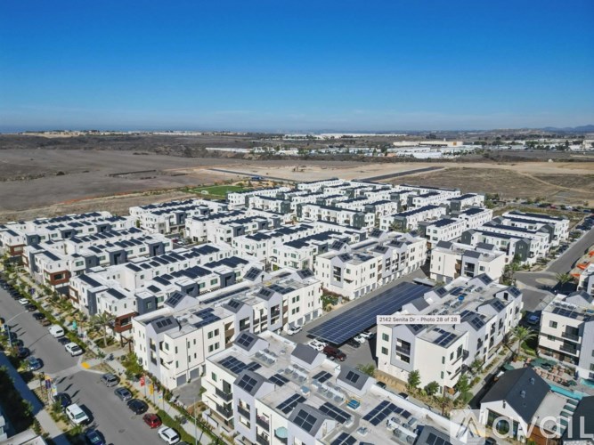 A large residential area with multiple buildings and solar panels on the roofs.