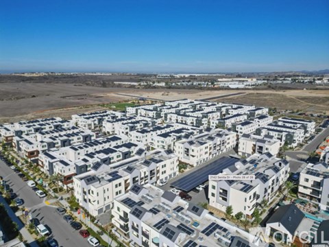 A large residential area with multiple buildings and solar panels on the roofs.