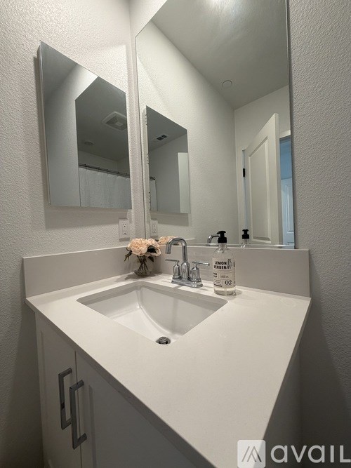 A white sink in a bathroom with a mirror above it.