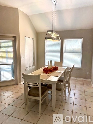 A dining room with a table set for four.