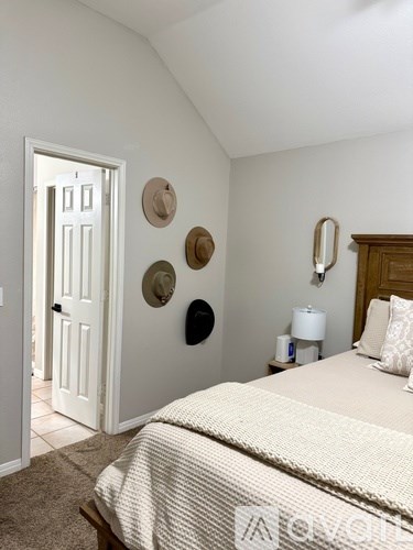 A bedroom with a bed, nightstand, and a door.