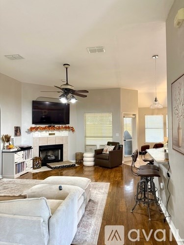 A living room with a fireplace and a television mounted on the wall.