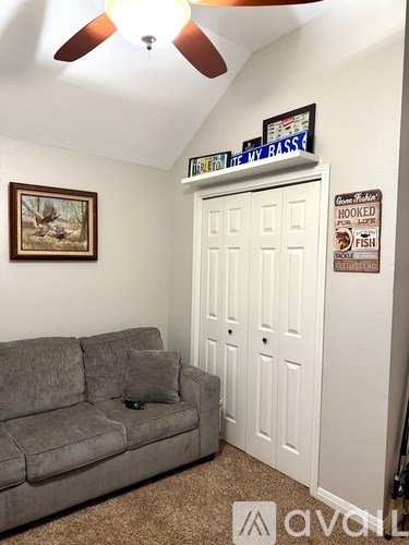 A living room with a grey couch and a white door.