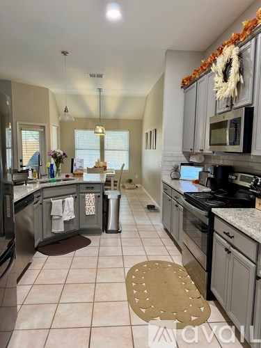 A kitchen with a dining table and chairs.