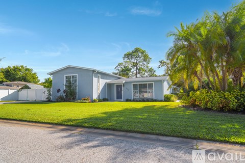 A house with a white exterior and a green lawn in front.