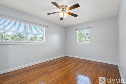 A room with wooden floors and a ceiling fan.