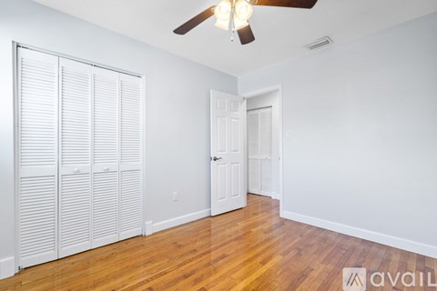 A room with a ceiling fan and a door.
