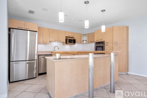 A kitchen with a refrigerator, microwave, oven, and sink.