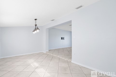 A large empty room with a light hanging from the ceiling.