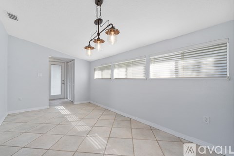 A room with a chandelier and a door is available for rent.