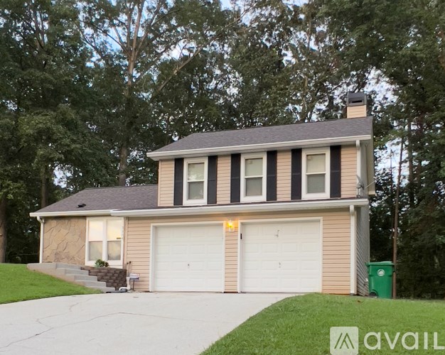 A two-car garage is attached to a house with a brown and beige exterior.