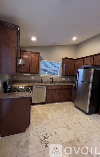 A kitchen with brown cabinets and a tiled floor.