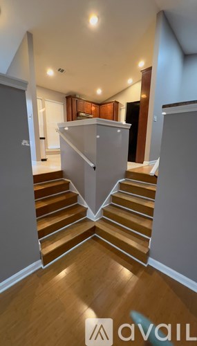 A staircase with wooden steps and a white railing.