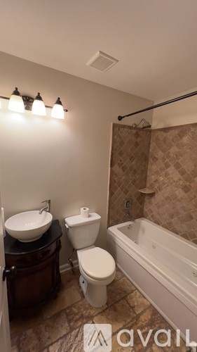 A bathroom with a toilet, sink, and bathtub.