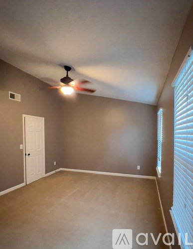 A room with a ceiling fan and a door.