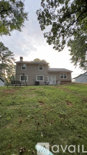 A house with a lawn and trees in the background.