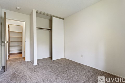A room with a carpeted floor and a wall-mounted shelf.