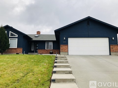 A two-story house with a garage and a driveway.