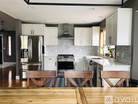 A kitchen with a wooden table in the foreground.