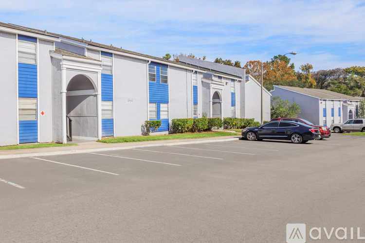 A parking lot with a building and cars parked in front.