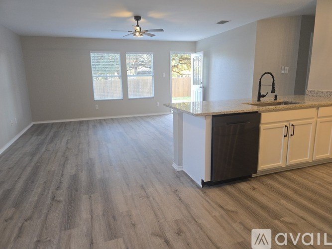 A room with a ceiling fan and carpeted floor.