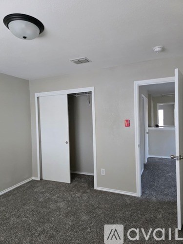 A room with a grey carpet and a white door.