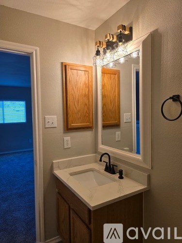 A bathroom with a sink, mirror, and a light fixture.